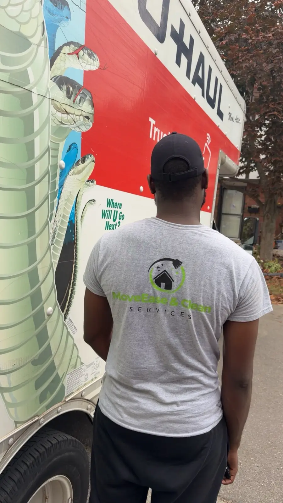 Crew member wearing the MoveEase & Clean Services t-shirt next to a moving truck