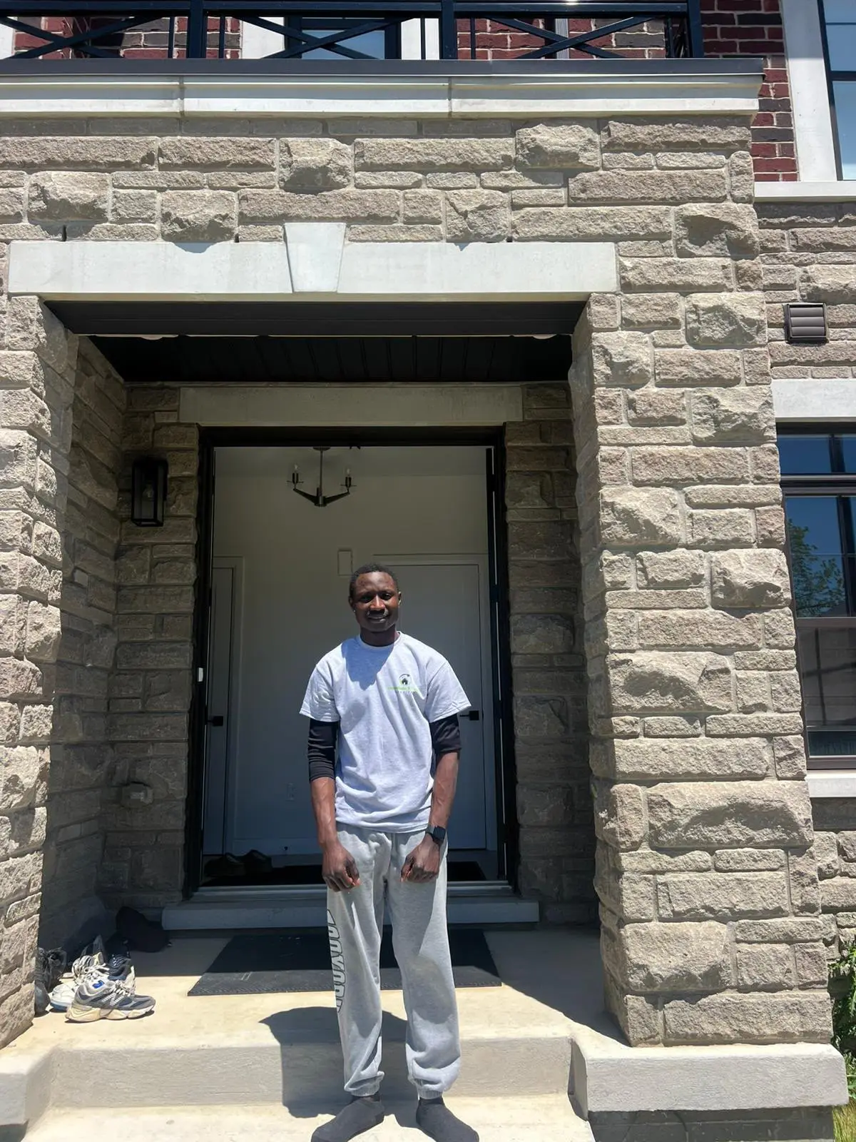 MoveEase & Clean crew member in a branded t-shirt standing at a client's front door